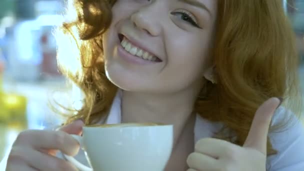 若い魅力的な女性はカフェでコーヒーを飲む. — ストック動画