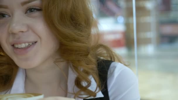 Donna rossa che beve cappuccino nel caffè . — Video Stock