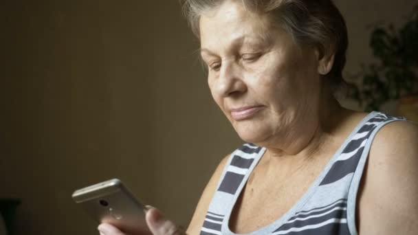 Mujer vieja usando nuevo teléfono inteligente . — Vídeo de stock