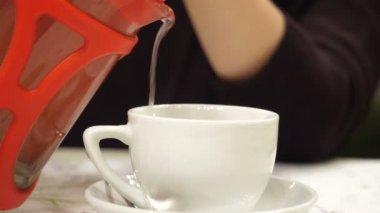 Beyaz Kupası'nda dökerek sıcak çay üzerinde yakından görmek.