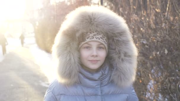 Niña de pie y sonriendo en la cam en el parque de invierno . — Vídeos de Stock