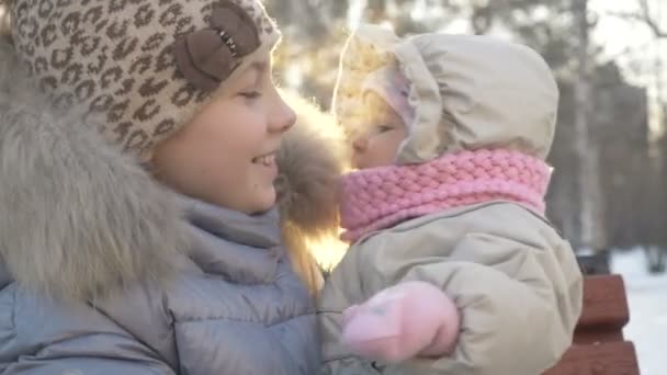 Ältere Schwester hält ihr kleines Baby im Winter. — Stockvideo