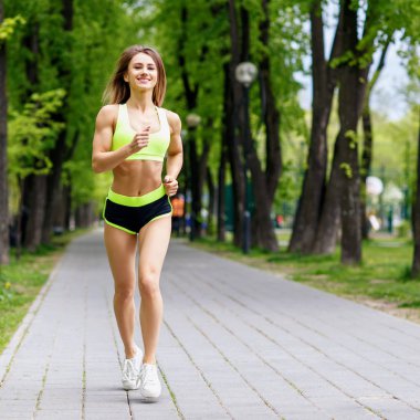 yeşil park içinde çalışan güzel bir genç kadın.