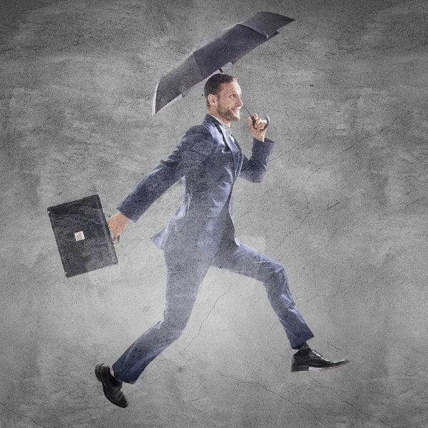 Affärsman som kör med paraply och portfölj. — Stockfoto