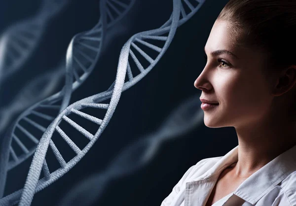 Mujer tecnóloga en laboratorio entre cadenas de ADN . — Foto de Stock