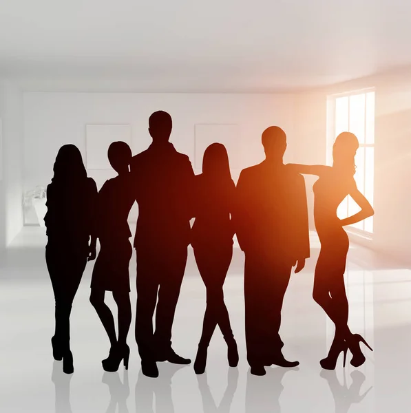 Silhouette di businessteam gruppo in piedi in ufficio luminoso . — Foto Stock
