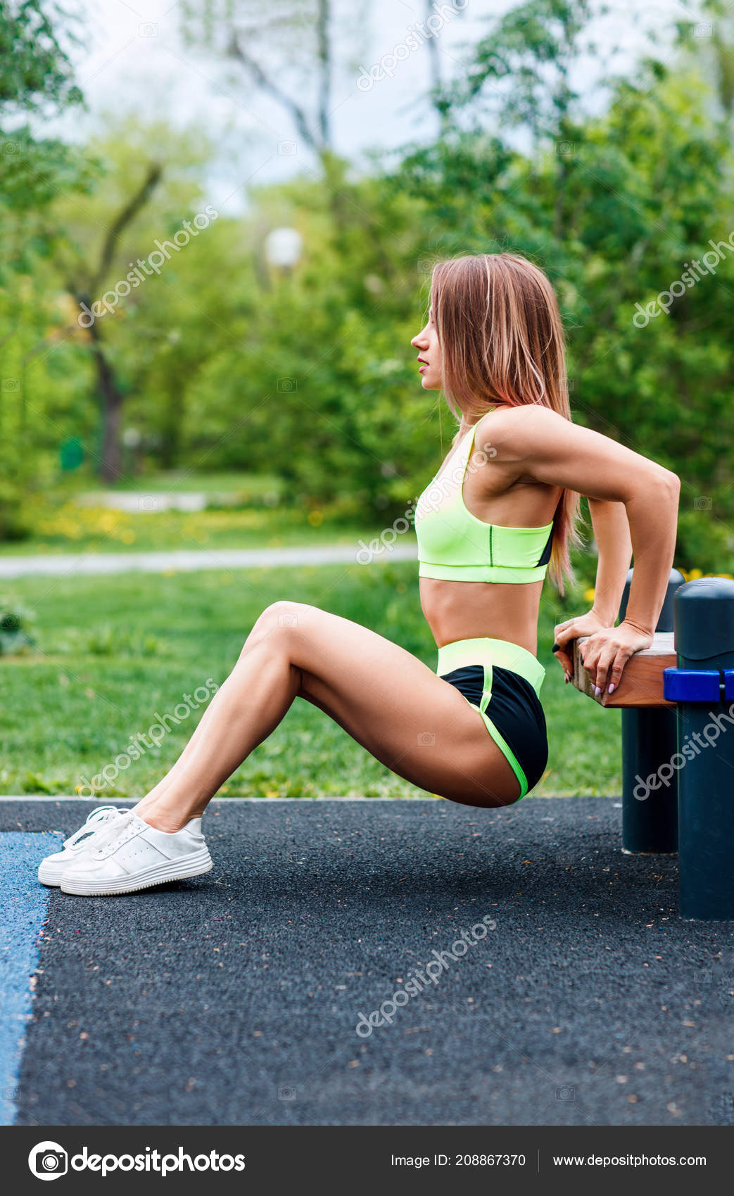 Young Sporty Woman Doing Triceps Dip Exercise On City Street Bench