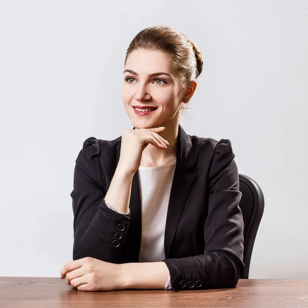 Retrato de una joven mujer de negocios sentada a la mesa . —  Fotos de Stock