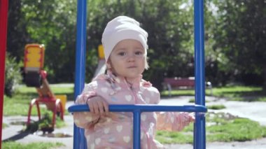 Sevimli küçük kız yaz parkta salıncak üzerinde.