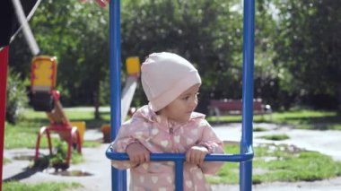 Sevimli küçük kız yaz parkta salıncak üzerinde.