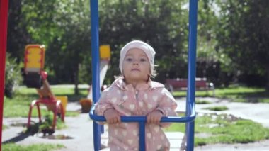 Sevimli küçük kız yaz parkta salıncak üzerinde.