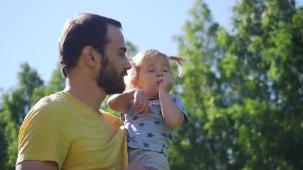 Joven padre muestra y explica a su pequeña hija . — Vídeos de Stock