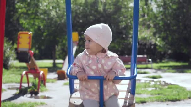 Menina bonito no balanço no parque de verão . — Vídeo de Stock