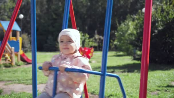 Schattig klein meisje op schommel in zomer park. — Stockvideo