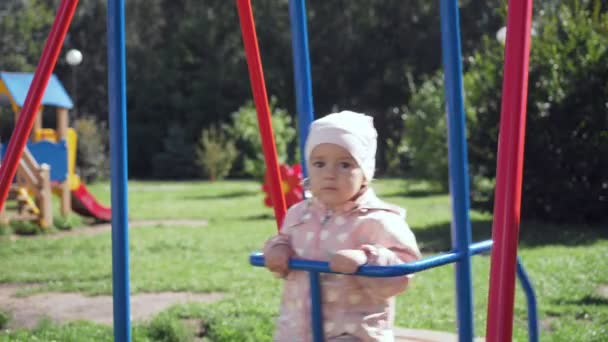 Schattig klein meisje op schommel in zomer park. — Stockvideo