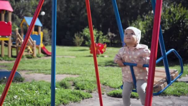 Schattig klein meisje op schommel in zomer park. — Stockvideo