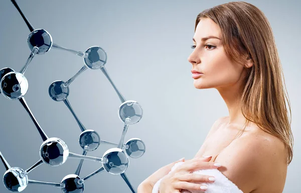 Beautiful woman in bathrobe near glass molecules. — Stock Photo, Image