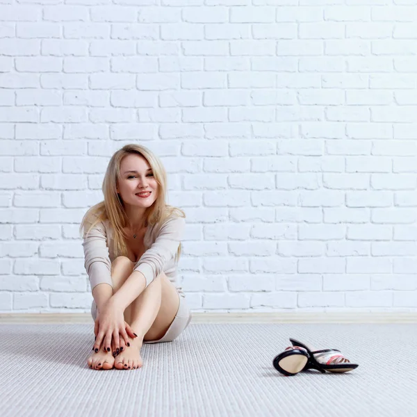 Young lovely woman in dress sitting on the floor and posing. — Stock Photo, Image