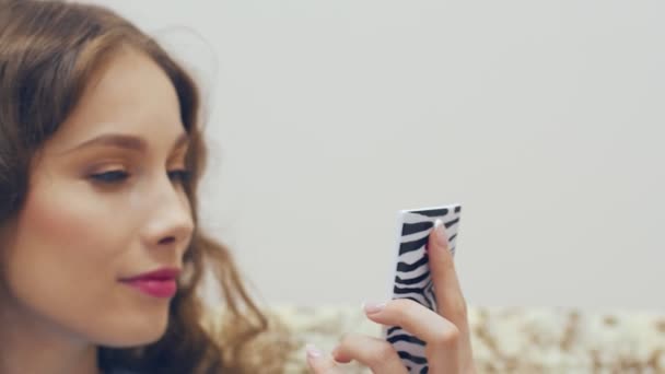 Молода жінка дивиться у дзеркало і перевіряє свій макіяж . — стокове відео