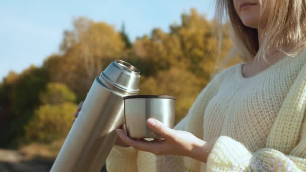 Jeune femme en versant du thé chaud avec de la vapeur du thermos à la tasse . — Video