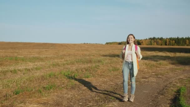 Mujer joven con mochila rosa caminando — Vídeos de Stock