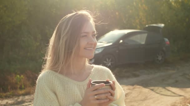 Beautiful admiring woman drinking hot tea from thermos cup — Stock Video