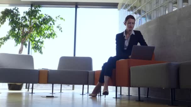 Femme d'affaires confiante travaillant sur un ordinateur portable dans la zone de repos . — Video