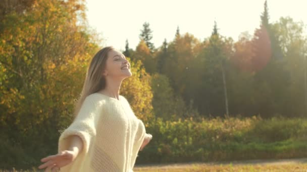 Улыбающаяся молодая женщина наслаждается природой осенью . — стоковое видео
