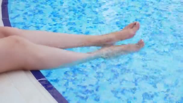 Weibliche Beine planschen im Pool. — Stockvideo