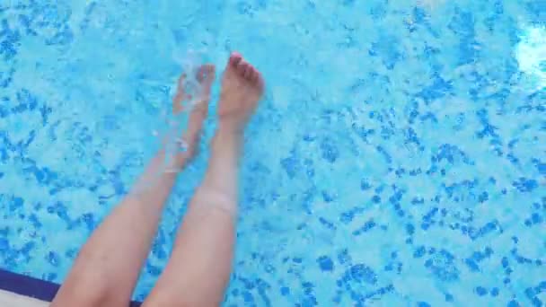 Kvinnliga ben plaskade i poolen. — Stockvideo