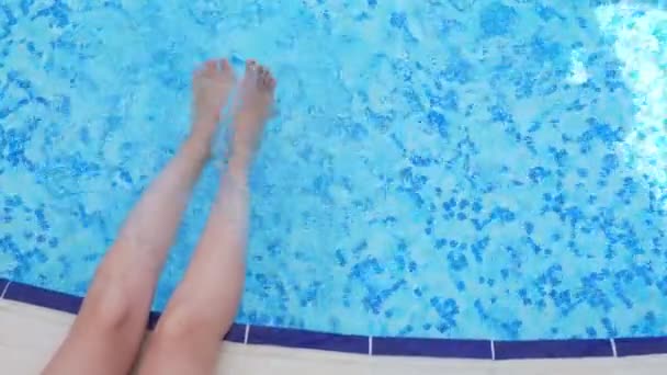 Piernas femeninas salpicando en la piscina . — Vídeos de Stock