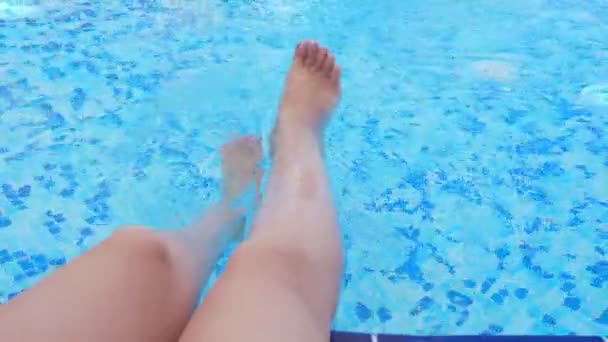 В бассейне брызгают женские ноги . — стоковое видео