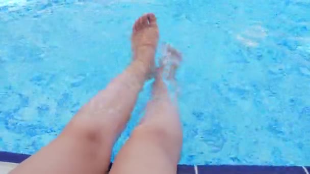 Female legs splashing in pool. — Stock Video