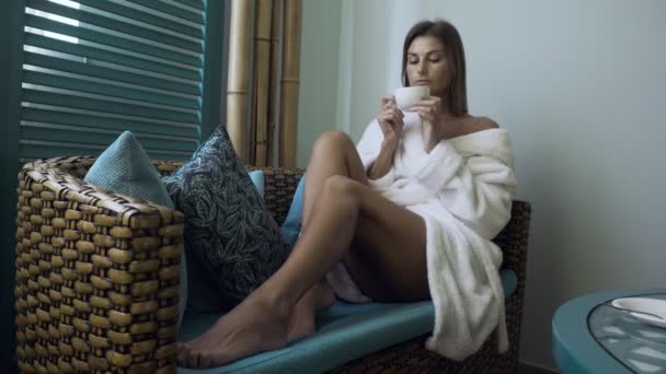 Vrouw in badjas het drinken van thee in spa salon. — Stockvideo