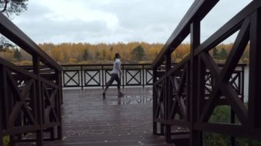 Sportif kadın sıcak-up üzerinde ahşap iskele koşu önce.