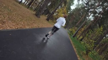 Sonbahar parkta çalışan genç sportif kadın.