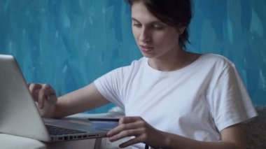 Kadın online alışveriş yapar ve plastik kart tarafından öder.