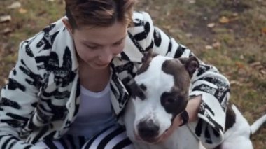 Kadın yerde oturan ve onu Stafford köpeği kucaklayan.