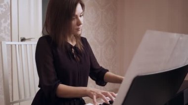 Genç kadın piyanist büyük piyano oynuyor