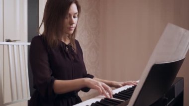 Genç kadın piyanist büyük piyano oynuyor