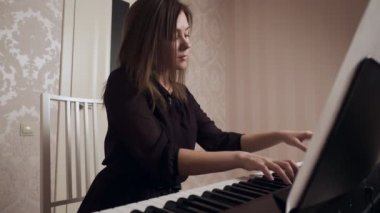 Genç kadın piyanist büyük piyano oynuyor