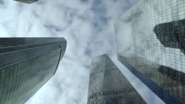 Κάτω άποψη από σύγχρονες ουρανοξύστες συννεφιασμένο ουρανό φόντο. — Αρχείο Βίντεο