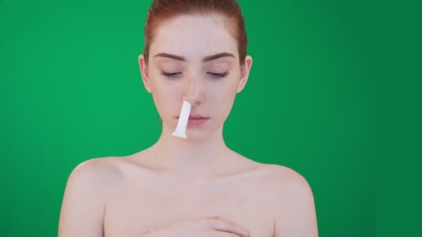 Young redhead woman with blocked nose using inhalation stick. — Stock Video