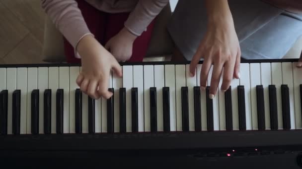 Κορυφαία θέα στον δάσκαλο με μικρό κορίτσι που παίζει στο ηλεκτρικό πιάνο. — Αρχείο Βίντεο