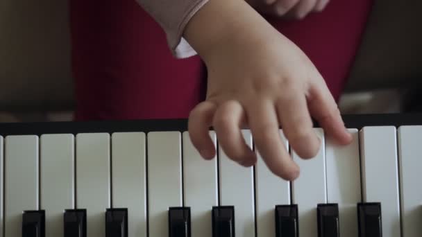 Draufsicht auf die Hände eines kleinen Mädchens, das auf dem E-Piano spielt. — Stockvideo