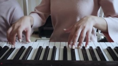 Elektrikli piyano çalan küçük kız ile Öğretmen.