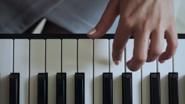 Blick von oben auf Lehrer mit kleinem Mädchen, das auf dem E-Piano spielt. — Stockvideo