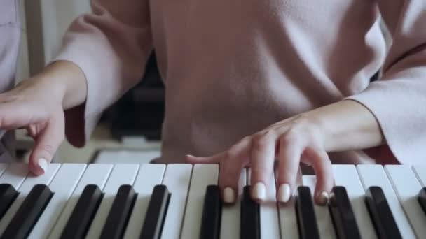 エレクトリックピアノで遊ぶ小さな女の子を持つ教師. — ストック動画