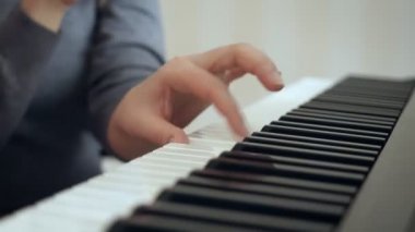 Yakın çekim kadın elleri piyano çalmayı gösterir.