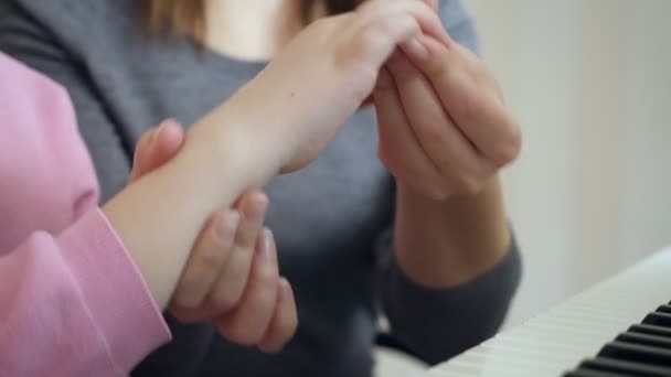 Jovem mulher ensina a menina como tomar a mão direita . — Vídeo de Stock